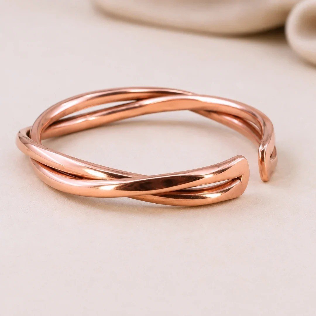 Close-up of a woman's hand wearing a twisted copper kada